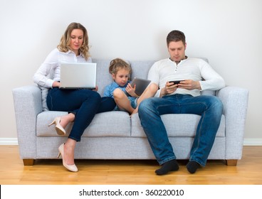 Modern Family Values. Father, Mother And Daughter Using Electronic Devices.