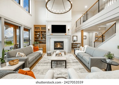 Modern farmhouse interior living room with hardwood floors built in shelving book case gas fireplace mantel vaulted ceiling large windows with view stair case with wrought iron railings comfortable - Powered by Shutterstock