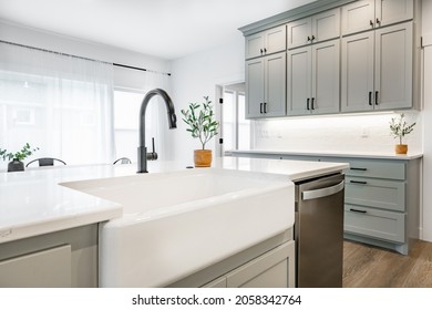 Modern Farmhouse Style Kitchen With Stainless Appliances White Counter Top Raw Wood Dining Table Kitchen Island And Mirror Reflection