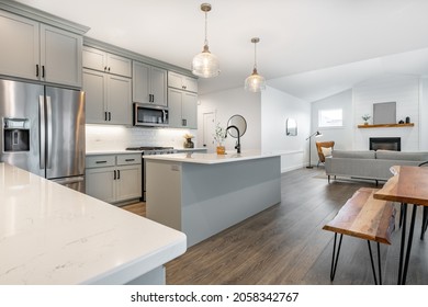 Modern Farmhouse Style Kitchen With Stainless Appliances White Counter Top Raw Wood Dining Table Kitchen Island And Mirror Reflection