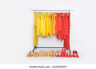 Modern fashion women colorful, clothes with dress, sweater, jacket hang on hangers rack , at clothing store department store with row of shoes 