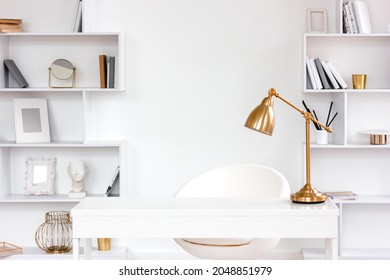 Modern fashionable freelance workplace with table, lamp, bookshelves. Minimalist style freelancer desk in white, remote work and home office concept