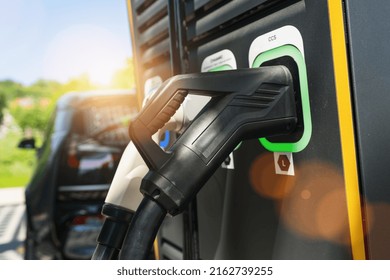 Modern fast 300KW Hypercharger or Supercharger for electrical or hybrid PHEV automobiles with DC CCS type 2 EV charging connector at EV charging station. Plug and Charge concept image.