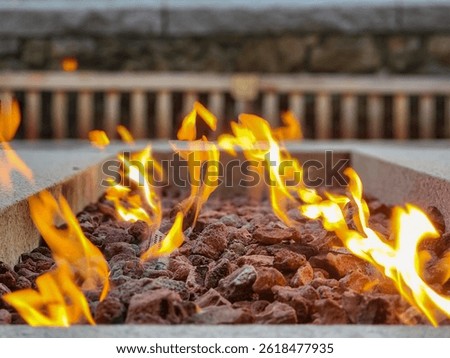 Modern Fire Pit Flames: Warm, inviting flames dance in a contemporary fire pit filled with red lava rock.  Great for cozy outdoor ambiance