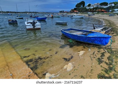 Modern fishing motorboats and old rowboats moored and stranded on the banks of the Ria do Alvor Estuary along with several tourist sailboats anchored in the harbor. Alvor Portimao-Algarve-Portugal. - Powered by Shutterstock