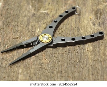 Modern Fishing Pliers On Wooden Background Close-up