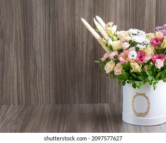 Modern Floral Arrangement In A Round Box On A Wooden Background