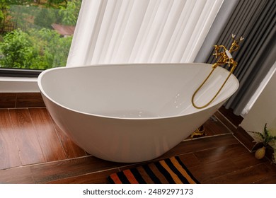 A modern, freestanding bathtub positioned near a large window with a view of lush greenery. This scene captures the blend of contemporary design - Powered by Shutterstock