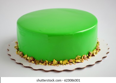 Modern French mousse cake with green mirror glaze. Picture for a menu or a confectionery catalog.