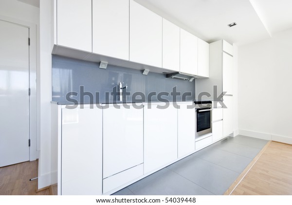 Modern fully fitted kitchen with kitchen appliances\
in white and gray