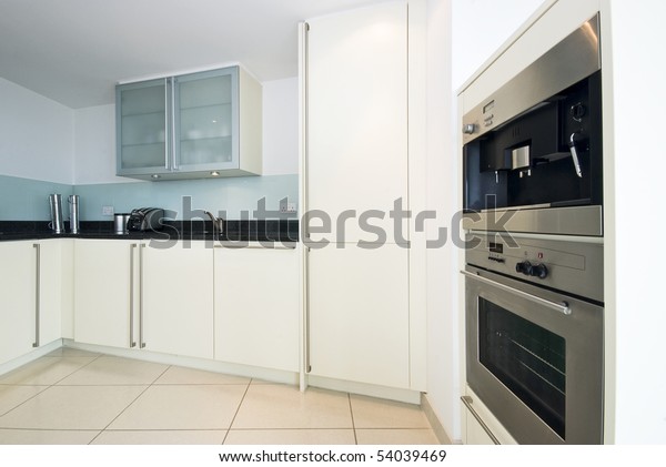 Modern fully fitted kitchen in\
vanilla white with built in coffee machine and microwave with\
grill