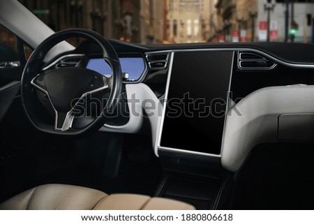 Modern and futuristic car steering wheel and futuristic monitor. Huge screen inside modern vehicle 