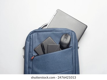 Modern gadgets For work and study. Backpack with laptop, notebook, external hard drive, pc mouse and power bank on white background. Top view. Flat lay - Powered by Shutterstock