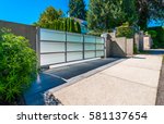 Modern gates with driveway to the luxury house.  North America.