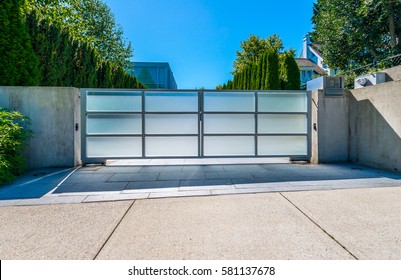 Modern gates with driveway to the luxury house.  North America.