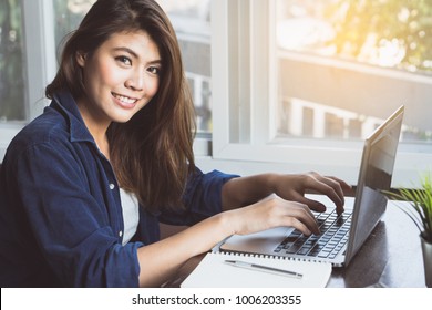 Modern generation of entrepreneur concept. Happy young asian women smiling and working on laptop computer at home.