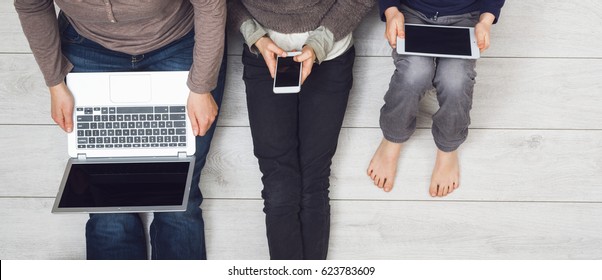 modern generation on wireless technology. Top view of young family using smartphone, tablet and laptop. - Powered by Shutterstock