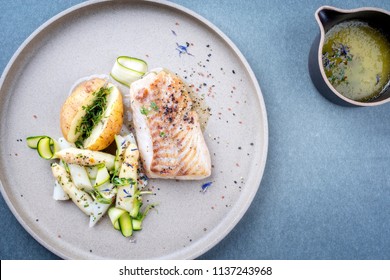 Modern German Fried Cod Fish Filet With White Asparagus Tips And Roast Potatoes As Top View On A Plate With Copy Space Right