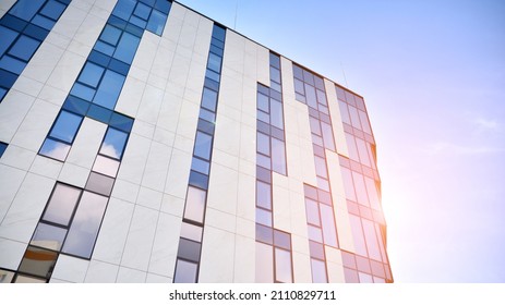 Modern glass and aluminum wall of office building outdoor with bright sun rays falling.