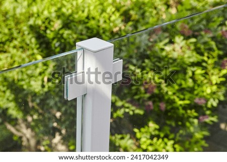 Modern Glass Balustrade Detail with Metal Clamps and Greenery Background Imagine de stoc © 