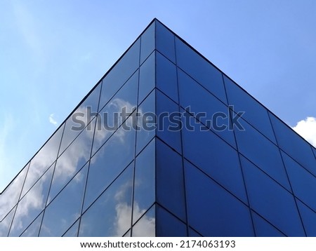 Modern glass building against the blue sky. Bottom view of modern skyscraper in business district