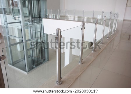 Modern glass elevator and glass railings