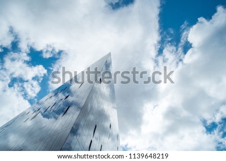 Modern glass facade office building against blue sky