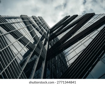 Modern glass skyscraper with angular facade viewed from below against cloudy sky in Tallinn city center, Estonia