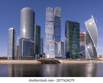 Modern glass skyscrapers and architecture in a waterfront cityscape on a sunny blue sky day with continuing construction and development in the background - Shutterstock ID 2077624279