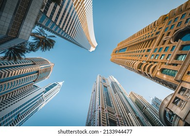 
Modern glass skyscrapers in Dubai with blue sky in background. Impressive architecture of financial district and Dubai marina. 
