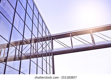 modern glass and steel office building with a bridge