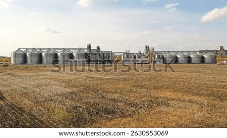 Modern grain elevator complex against a rural backdrop, highlighting agricultural infrastructure and food production processes