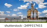 modern granary elevator with silver silos on agro-processing and manufacturing plant for processing drying cleaning and storage of agricultural products, flour, cereals and grain.