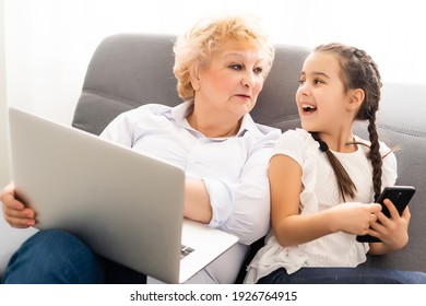 modern grandmother teaching grandchild how to use laptop computer at home - Powered by Shutterstock