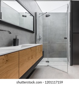 Modern, gray and black bathroom with shower and wooden cabinet