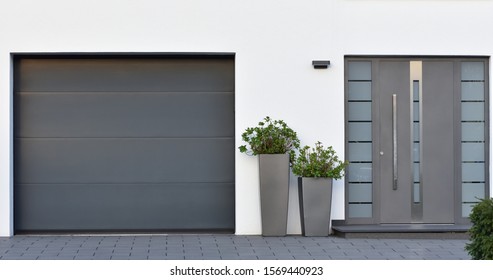 Modern gray garage, next to the Scandinavian-style house. Private garage with automatic door in a European city in Germany