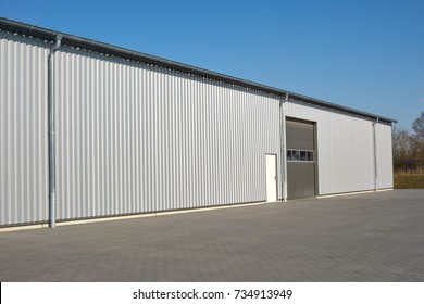 Modern gray warehouse with sheet metal cladding and large roller door