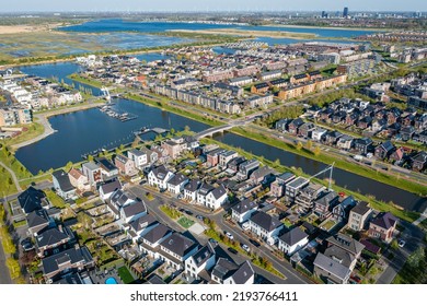 Modern green neighbourhood in Almere, The Netherlands, surrounded by water and nature, city built on reclaimed land (Flevoland polder). Aerial view. - Shutterstock ID 2193766411