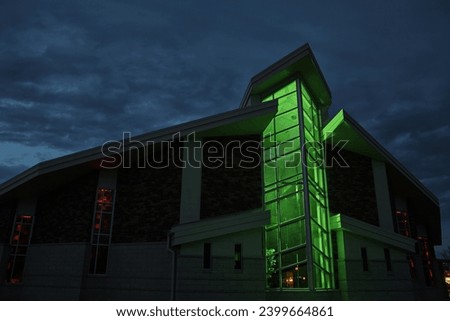 Modern Green-lit Church at Twilight with Red Accents