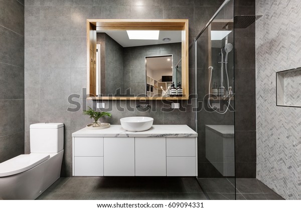 Modern grey designer bathroom with herringbone\
shower tiling