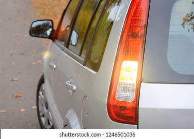 Modern grey hatchback car showing with turn signal lights beginning of moving on the road on the countryside - Shutterstock ID 1246501036