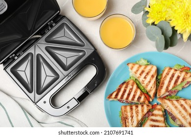 Modern grill maker, juice and sandwiches on white table, flat lay