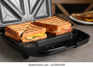 Modern grill maker with tasty sandwiches, closeup view