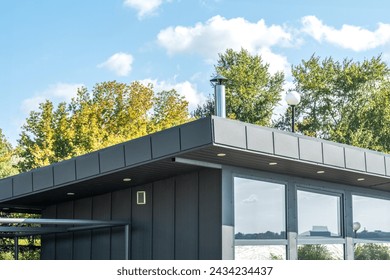 Modern guest house with standing seam facade panoramic glazing and large flat roof overhang in park. Minimalist architectural style of public building - Powered by Shutterstock