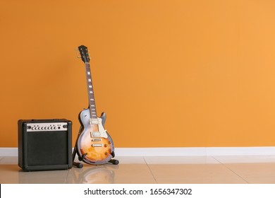 Modern guitar and amplifier near color wall - Powered by Shutterstock