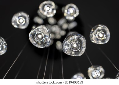 Modern hanging lamp lights with black background. Close-up view of crystal balls of contemporary chandelier