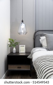 modern hanging lamp with picture frame on side table in bedroom at home