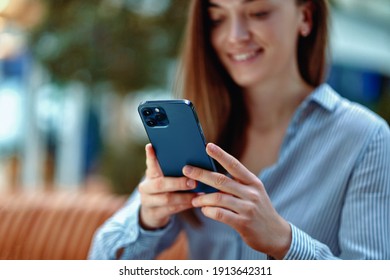 Moderne, glückliche, attraktive, lässige, smarte Jahrtausendfrau mit Telefon für das Surfen im Internet und Chat         