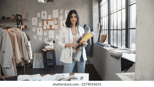  Modern Happy smiling Young attractive Asian woman or female professional fashion stylist standing in a designer office and looking at the camera. self-employment and startup concept. - Powered by Shutterstock