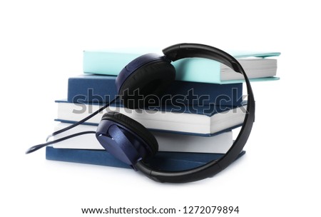 Modern headphones with hardcover books on white background